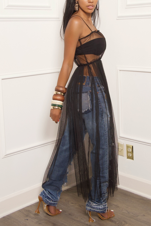 A black woman wearing jeans and a sheer tulle dress