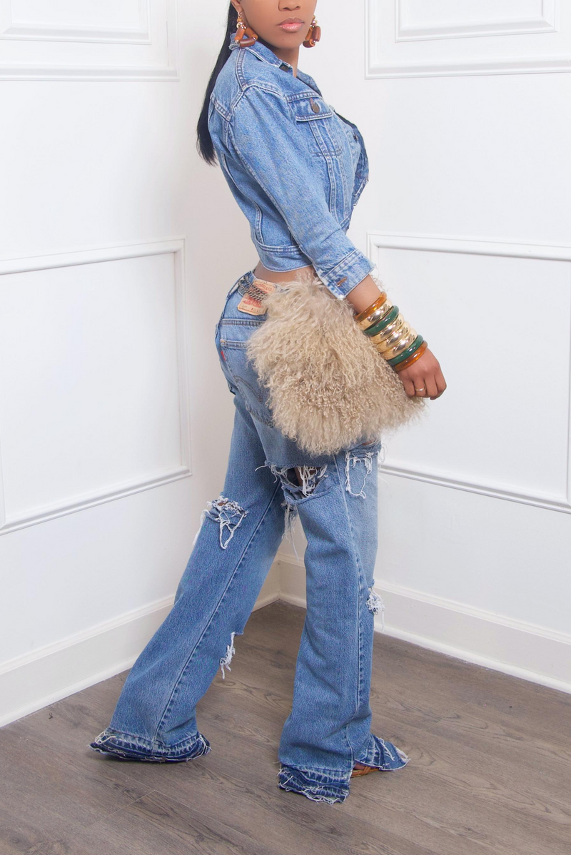 Woman in a denim outfit posing with a handcrafted Mongolian fur purse.