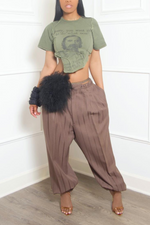 Woman in a cropped graphic t-shirt and high-waisted trousers holding a Genuine Fur Chain Purse.