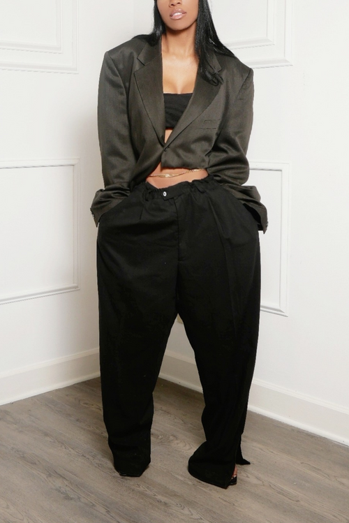 A woman wearing sleek and stylish black oversized side split slacks and a blazer.
