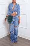 A woman wearing an upcycled denim crop jacket and Medium Washed Slit Ripped Levi Jeans with accessories.